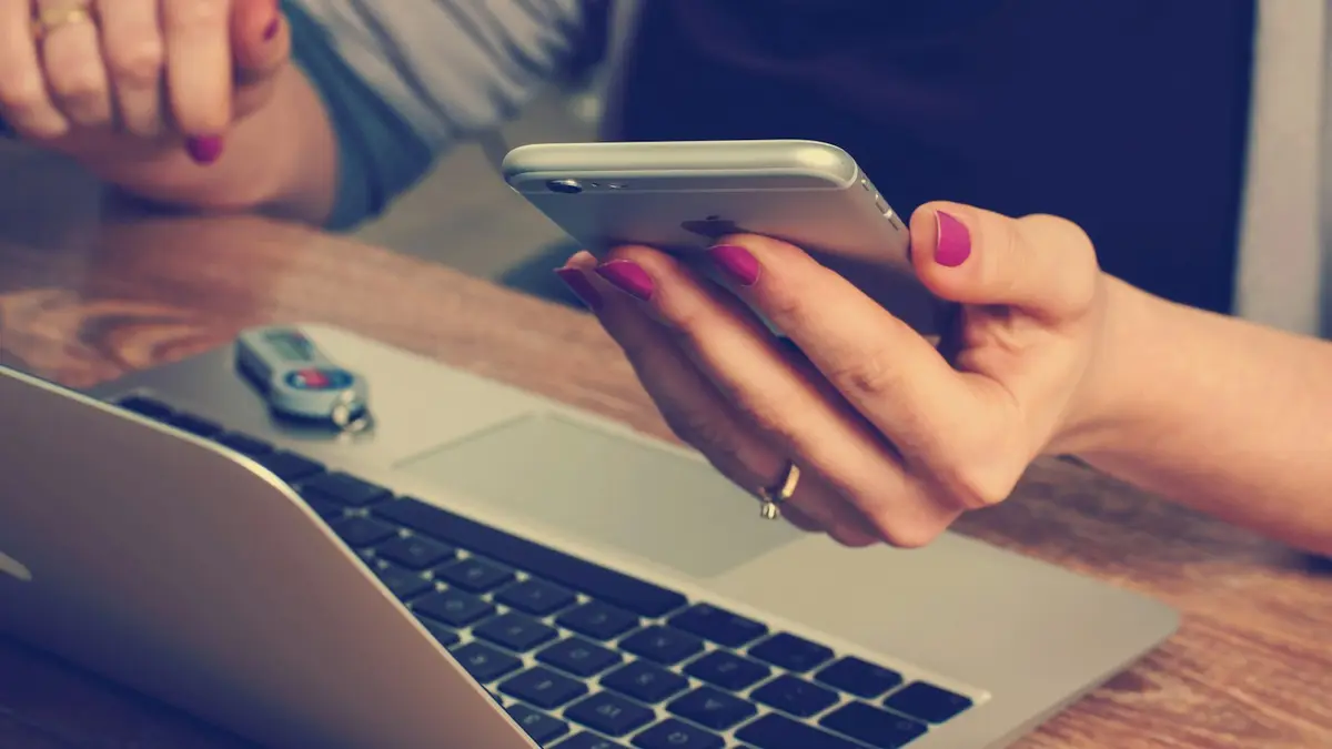 Celular e notebook conectados sobre uma mesa de trabalho